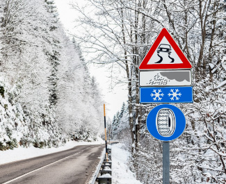 Verkehrsschild Schneekettenpflicht auf winterlicher Passstraße